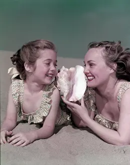Conch: Mother And Daughter Laying On The Beach