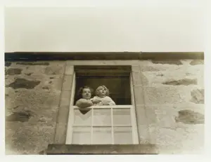 Sepia Images: Mother and daughter looking out of window, Scotland