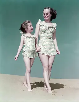 Mother and Daughter Walk Along Beach