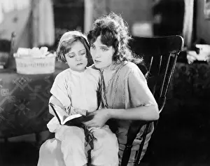 Saddened: Mother reading to her daughter