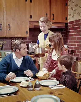 Kitchenware: Mother about to Serve Family at Table in Kitchen