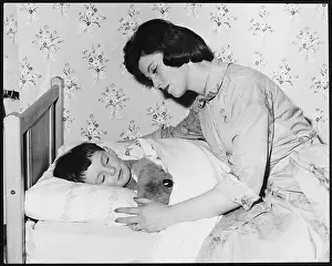 Bedtime: MOTHER TUCKS SON IN