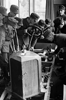 Explains: Motor HJ members study car engines, 1940