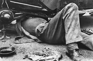 Jacked: Motor mechanic at work under a car
