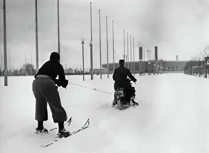 Reichssportfeld: A motorcycle rider pulling a skier