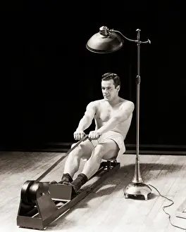 Chested: Muscular Bare Chested Man Exercising on a Rowing