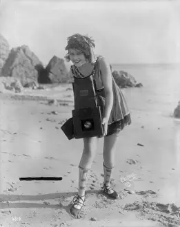 Graflex: Myrtle Lind, a young woman posing with a ?