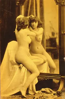 Drapery: Naked woman looking at her reflection in a mirror