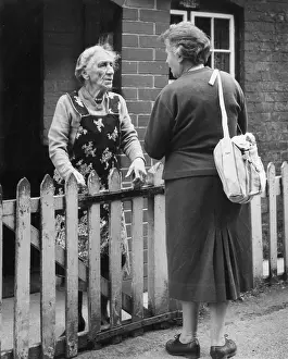 Neighbours: Two neighbours chatting over a fence