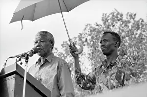 Madiba: Nelson Mandela, standing beneath an umbrella