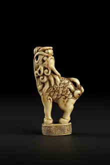 Bouch: Netsuke in the form of a kirin standing on a decorated base
