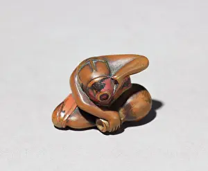 Lacquered: Netsuke in the form of a seated man draining his cup of sake