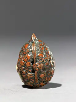 Netsuke: Netsuke formed from a walnut shell, carved with masks