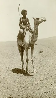 Nomad: A nomad riding a camel in the desert