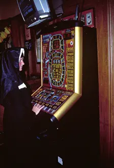 Amusements: Nun playing on a fruit machine