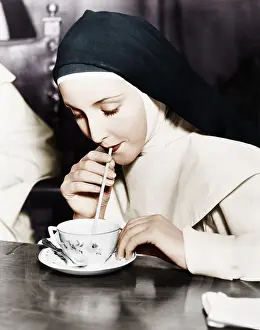Sipping: Nun sipping tea out of a teacup with a straw