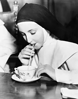 Teacup: Nun sipping tea out of a teacup with a straw