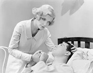 Consoling: Nurse consoling a man in a hospital bed