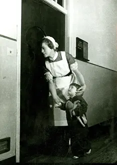 Nurse holding child's hand, looking in on an operation