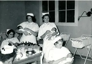 Nurses with babies in hospital nursery