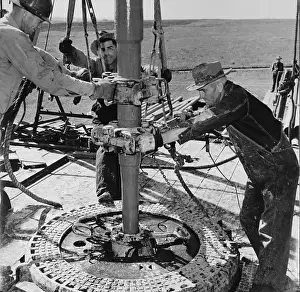 Clamped: Oil well worked by wildcat drillers. Roughnecks, ?
