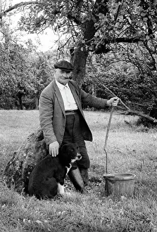 Smoker: Old farmer with dog in orchard
