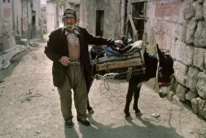 Miserable: An old man with a donkey in a back street of Avanos