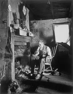 Old Man Sitting At Fireplace