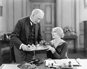 55 60: Older man serving a woman tea on a tray