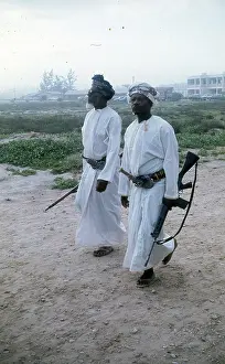 Omani elders wearing Khanjar and carrying rifles in Oman