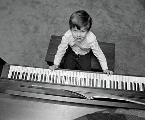 Keyboards: Overhead of boy sitting on bench with fingers