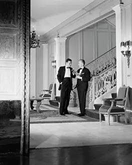 Nous: Pair of Men in Tuxedos Holding Drinks & Talking Shown T