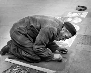 Grate: Pavement artist at work