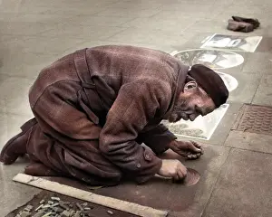 Grate: Pavement artist at work
