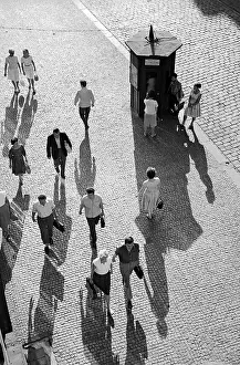 Cobble: Pedestrians - shadows - cobble stone - phone booth