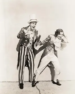 Firecracker: Two people in 18th century costumes playing with