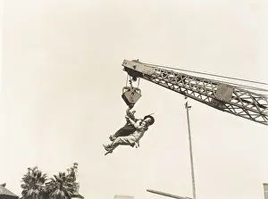 Mid Air: Two people dangling from crane