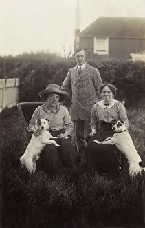Tweedy: Three people with two dogs in a garden