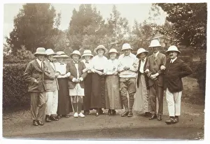 Sepia Images: Eleven people in a garden wearing pith helmets