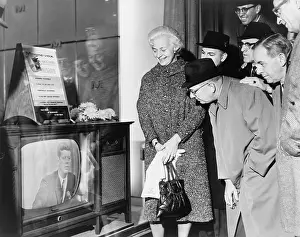Transistors: People gather around a television outside ?