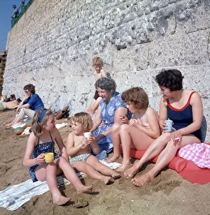 Towels: People having a drink on a sandy beach