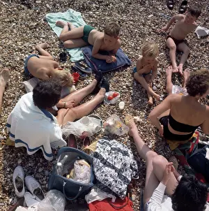 Towels: People having a picnic on a pebbly beach