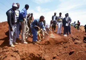 Gravedigger: People look on as the grave is filled with soil