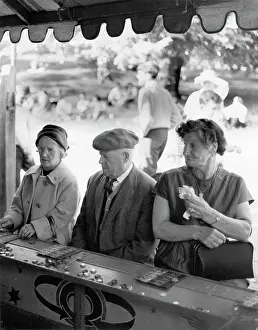 Markers: People play bingo at a fairground stall