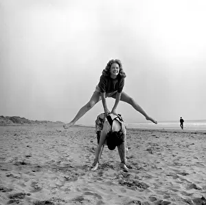 Leapfrog: Two people playing leapfrog on a beach