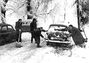 Snowbound: People trying to move a snowbound car