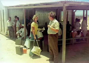 The British Caribbean History Collection: People waiting with luggage in Oman
