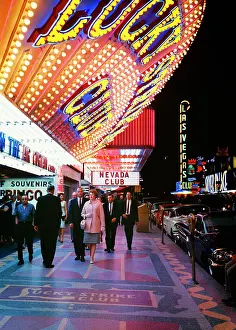 Flashing: People Walking on Sidewalk Beneath Large Neon