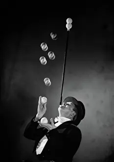 Strobe: Performer Wearing Top Hat and Tails Throwing Tennis