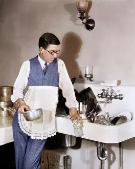 Perplexed: Perplexed Man in Apron Leaning on Sink Full of